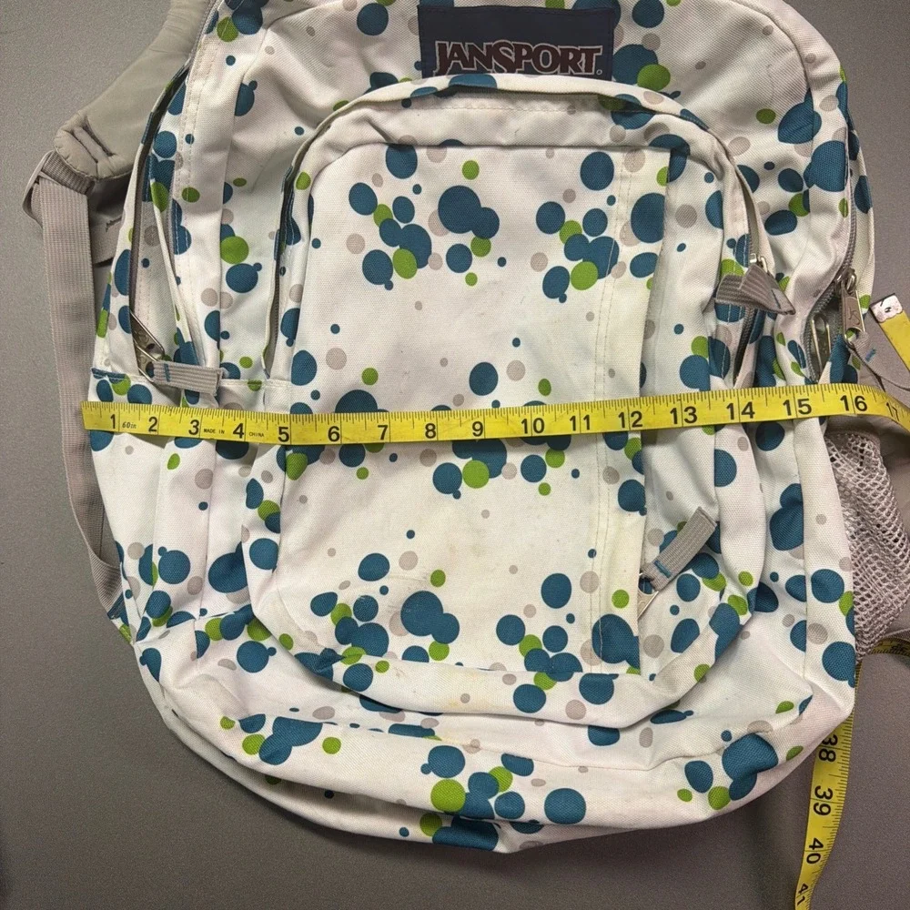 JanSport full-size backpack with a white, green, and blue polka dot pattern‎
